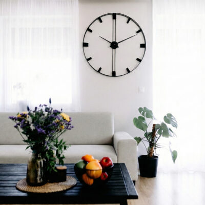 Nietypowy zegar ścienny z pionową deską dębową na białej ścianie, widok z boku