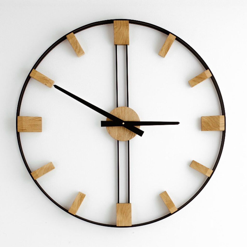 Duży zegar ścienny Elegance 96 cm z czarną ramą i naturalnymi dębowymi indeksami na białej ścianie