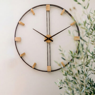 Prosty zegar ścienny z drewnianym środkiem i metalową obręczą w otoczeniu pnących roślin